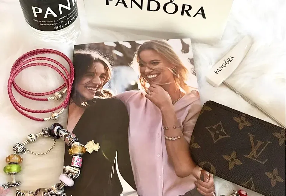 A picture of two women is surrounded by bracelets and a purse.