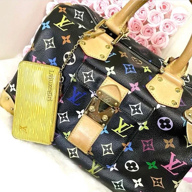 A black louis vuitton purse with a yellow wallet next to it