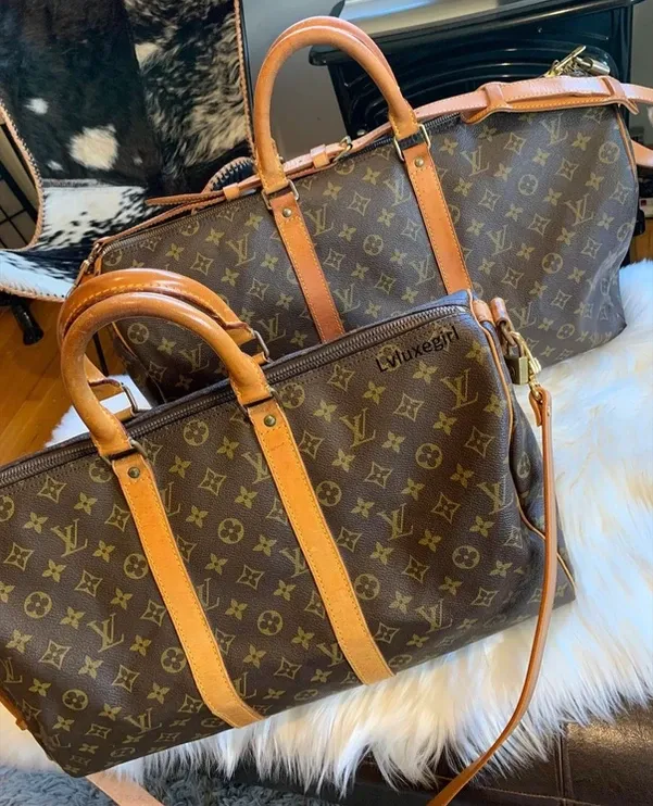 Two louis vuitton bags are sitting next to each other on a couch.