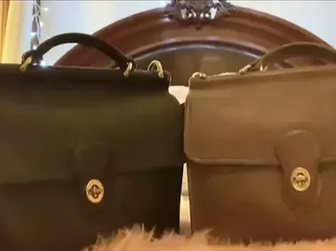 Two briefcases are sitting next to each other on a bed.