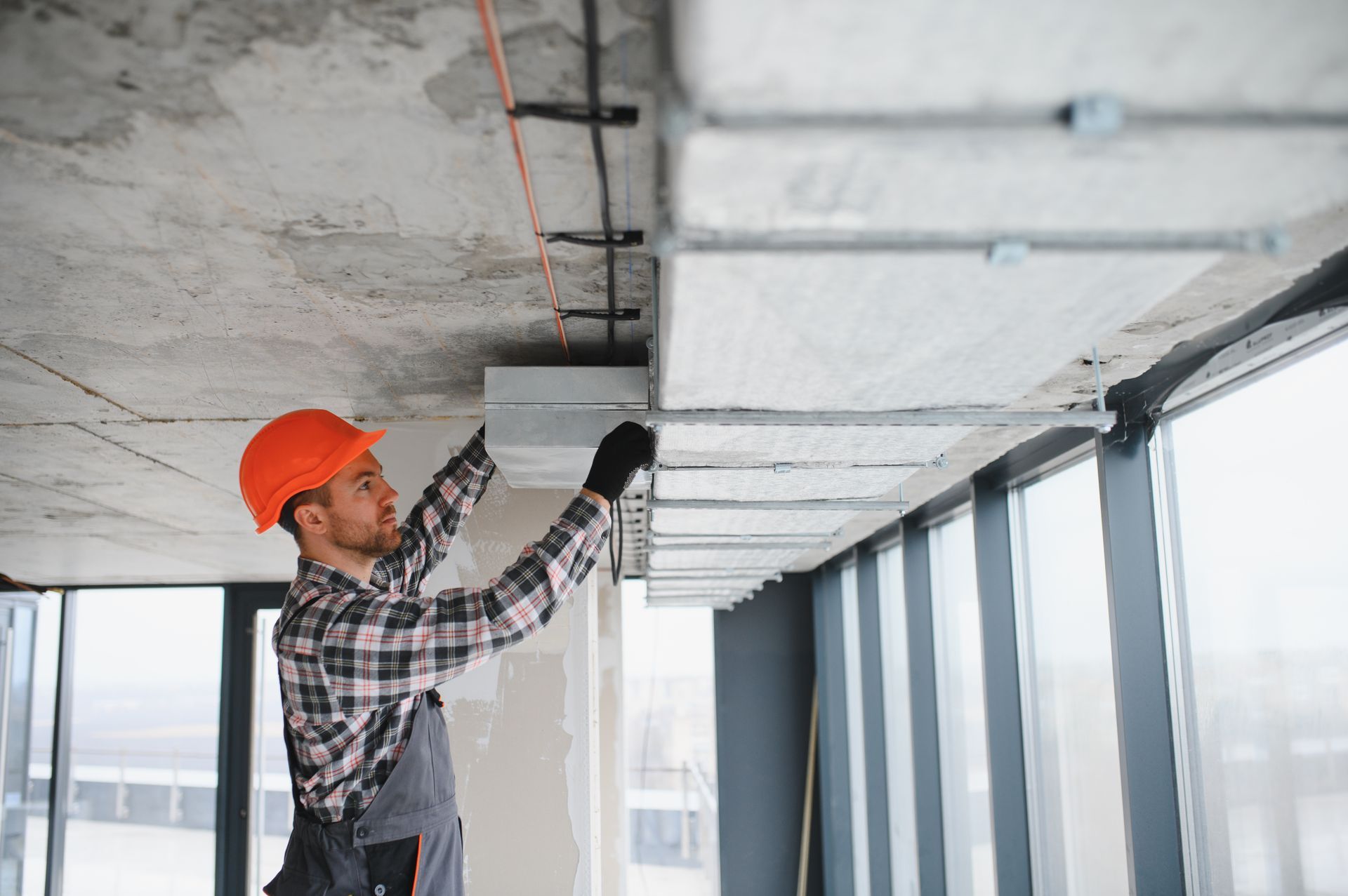 Woman in straw hat smiles, holding wine glass near a lake.
