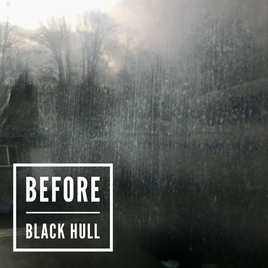 "Before" image of a dirty, streaked window with a blurred outdoor view.