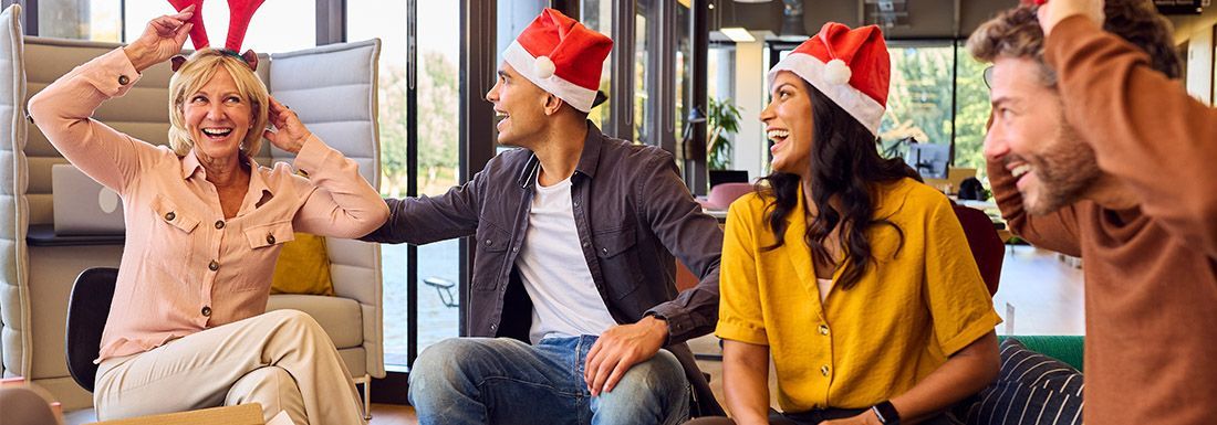 A group of four staff members dressed in Christmas hats at the staff party