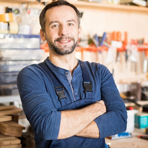 Business man in workshop looking at the camera with his arms crossed