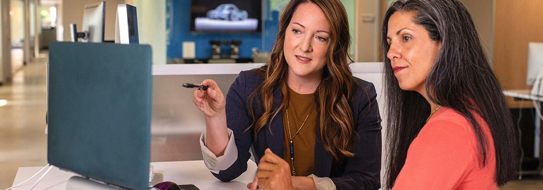 Two business woman looking at a computer