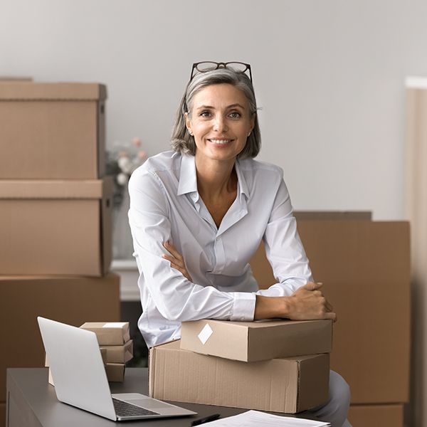 Business woman with laptop and boxes