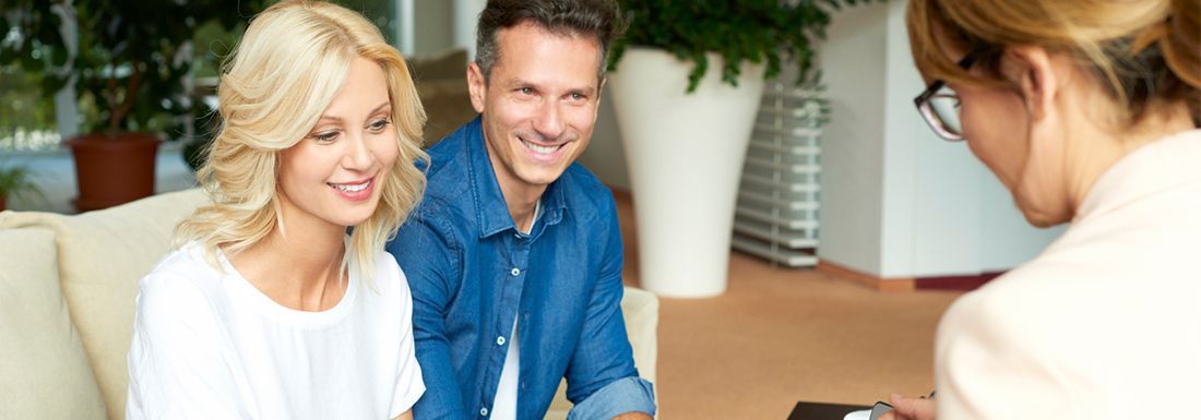 A female and male florist at a store counter looking at a computer.