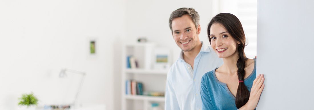 Young man and woman opening the door to their home