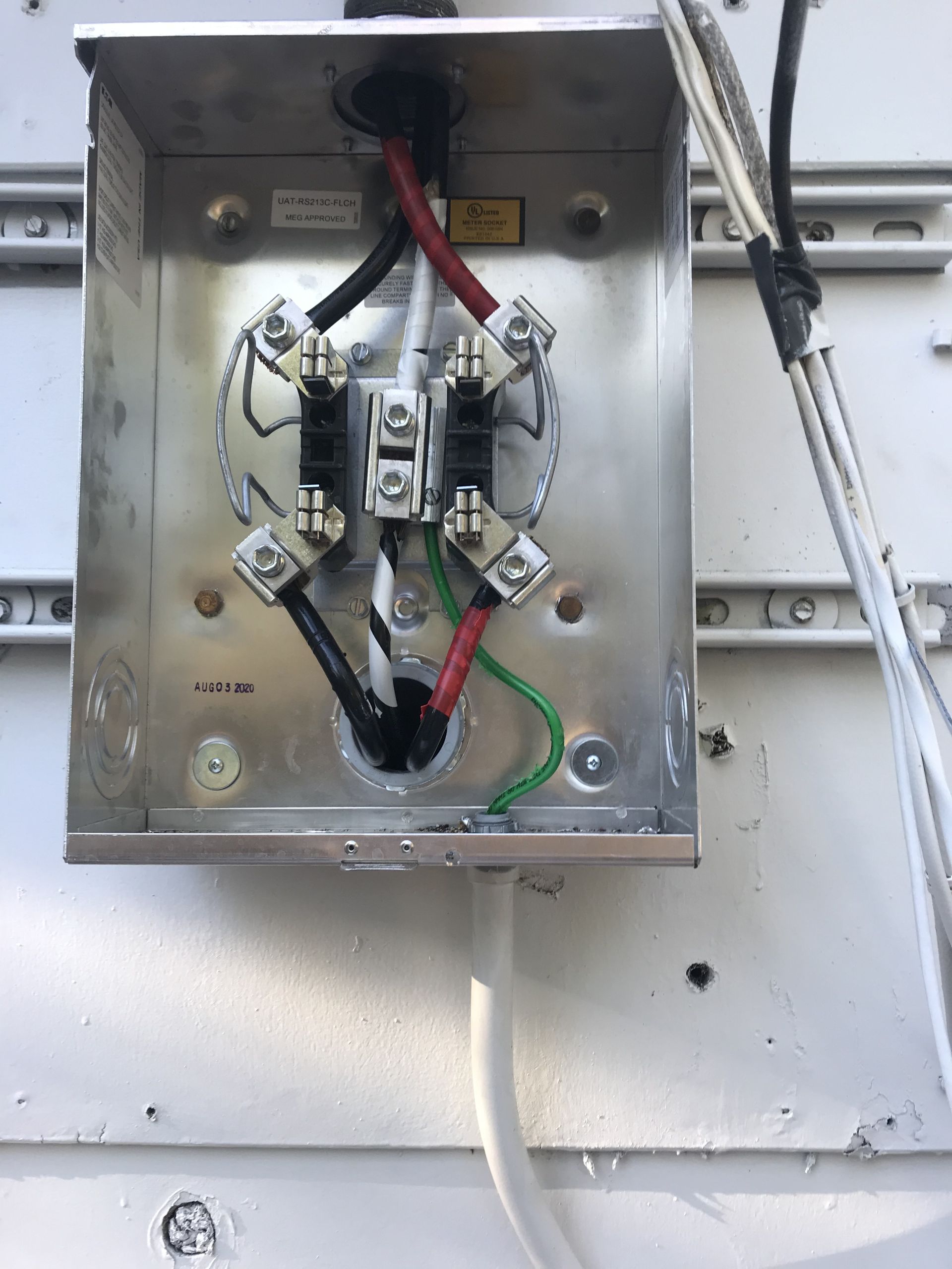 Inspection of electrical meter box wiring for home electrical installation and circuit breaker connection.