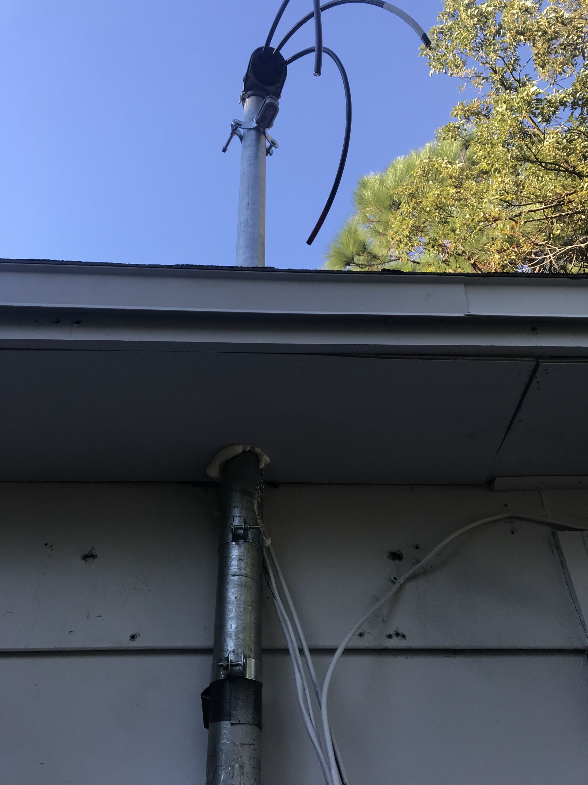 Service mast installation for electrical wiring and power supply connection to a residential property.