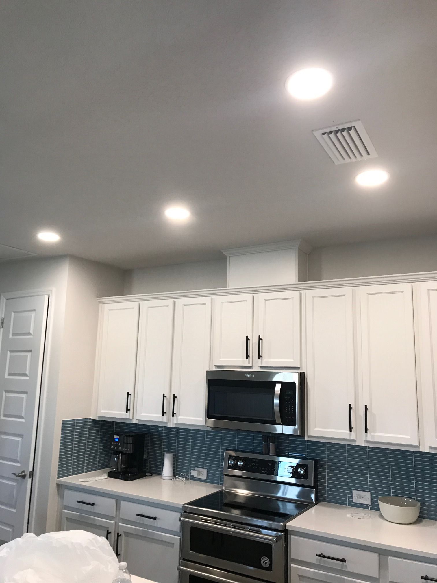 Home electrical installation of energy-efficient recessed ceiling lights for modern kitchen lighting solutions.