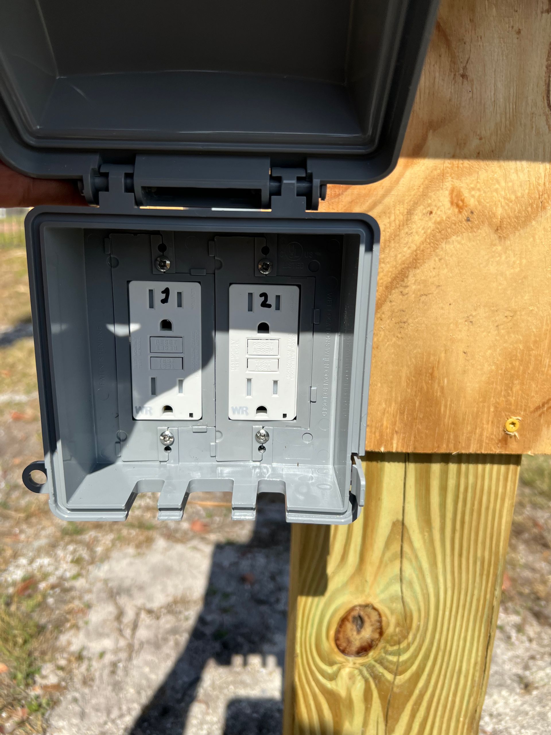 Installation of an outdoor GFCI electrical outlet with a weatherproof cover for safe and durable power access.