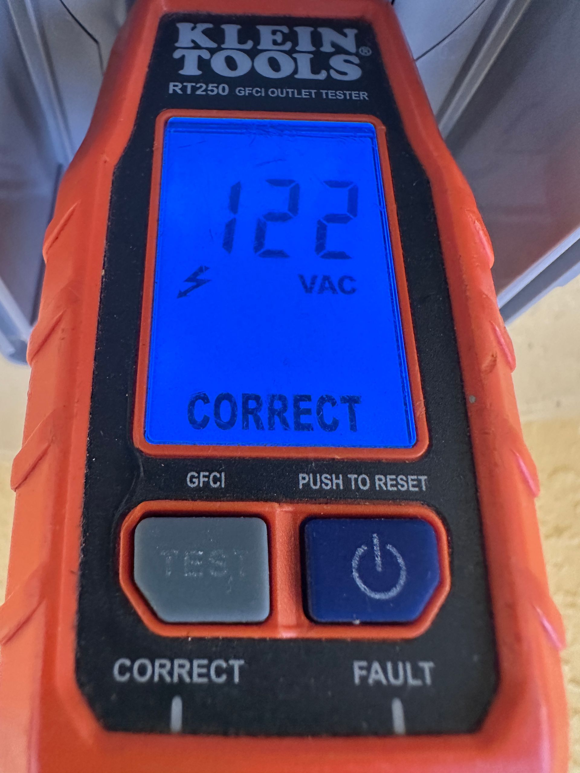 Electrical inspection with GFCI outlet tester showing 122V for circuit safety and reliable home electrical maintenance.