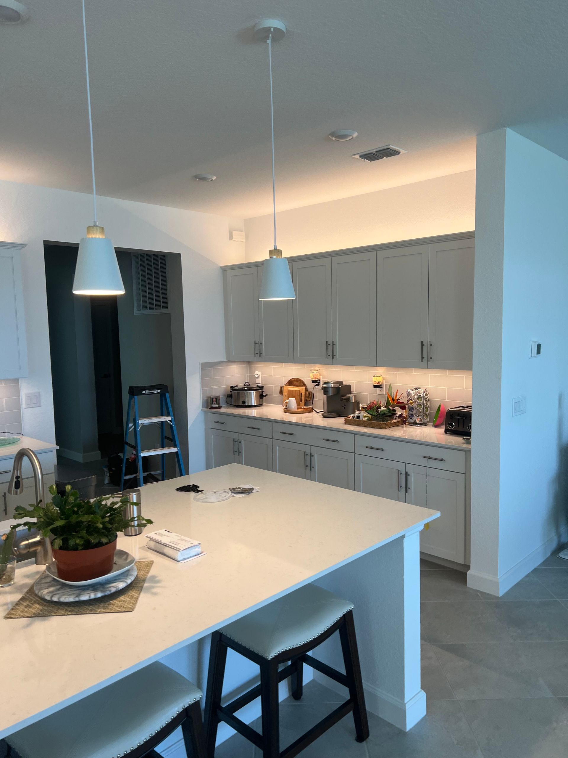 Professional electrical installation of pendant lights in a modern kitchen for enhanced lighting and energy efficiency.