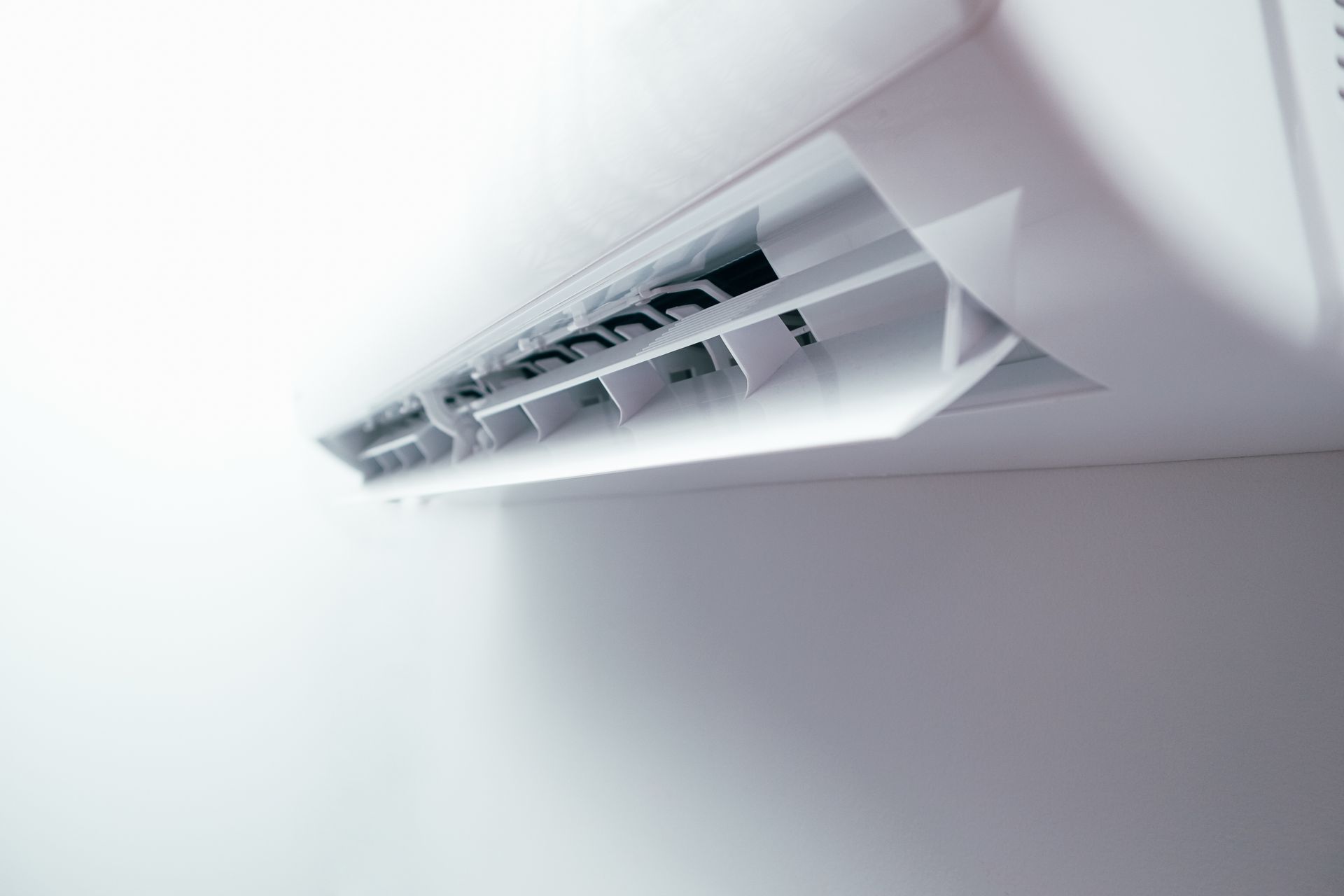 Scaldabagno a pompa di calore bianco e grigio con display digitale e spie luminose.