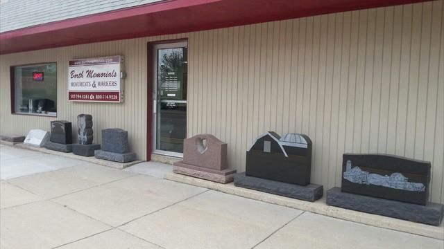 Tombstones displayed outside a building with sign for 
