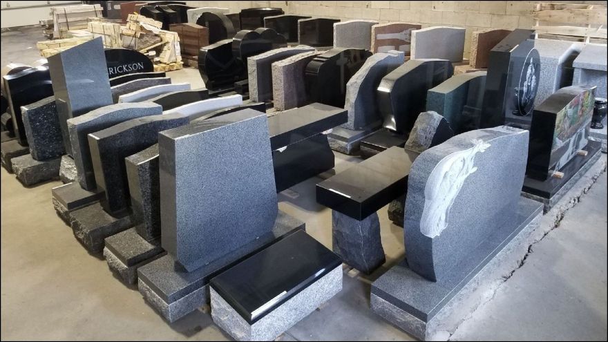 Rows of granite tombstones in various shapes and colors at a memorial business.