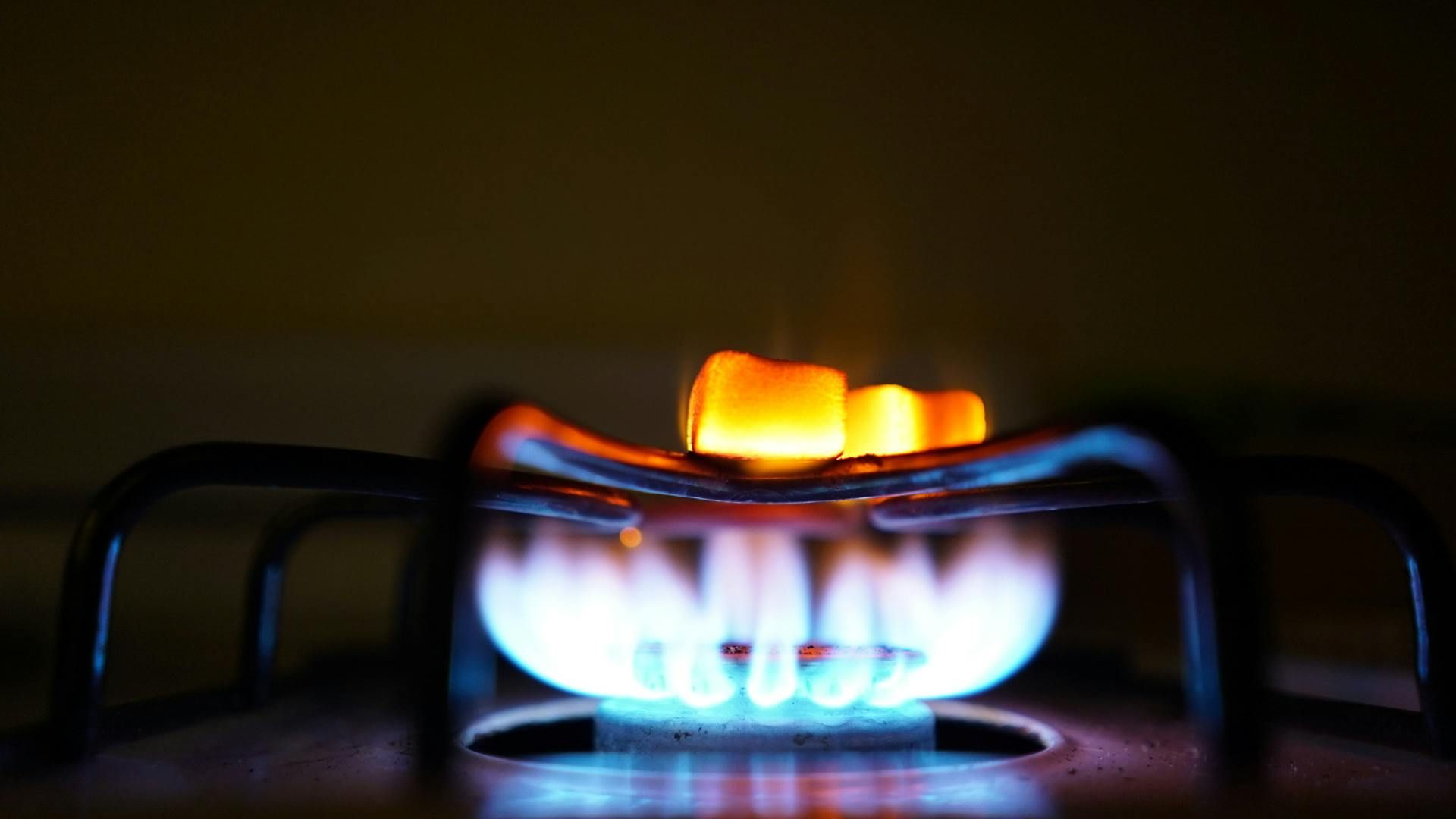 A close up of a gas stove with flames coming out of it.