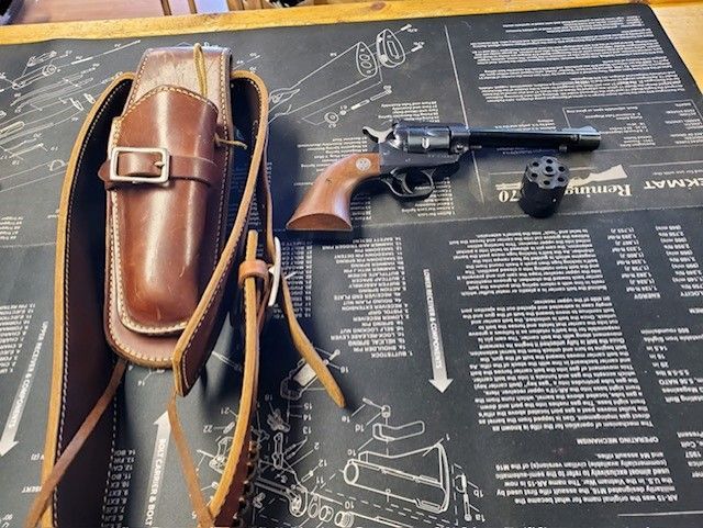 A brown leather holster and a revolver are on a table