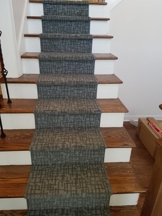 A set of stairs with a carpet on the steps.