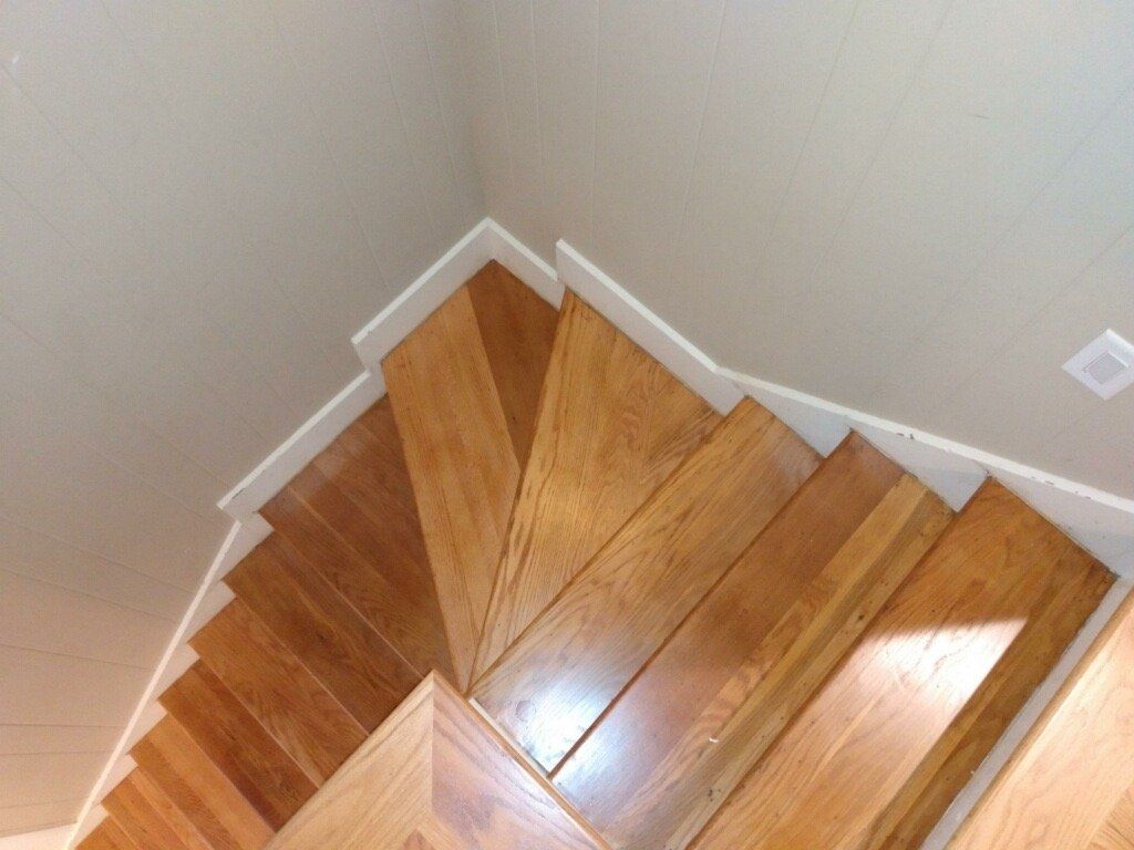 A set of wooden stairs with a white railing
