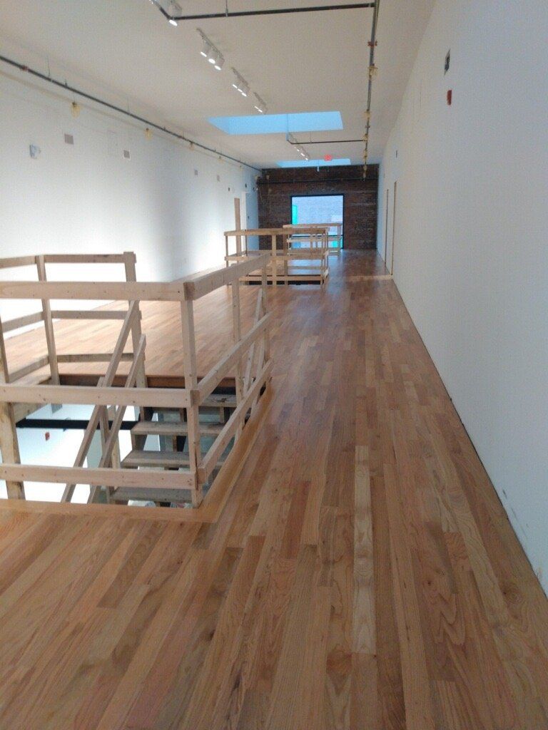 A long hallway with wooden floors and white walls