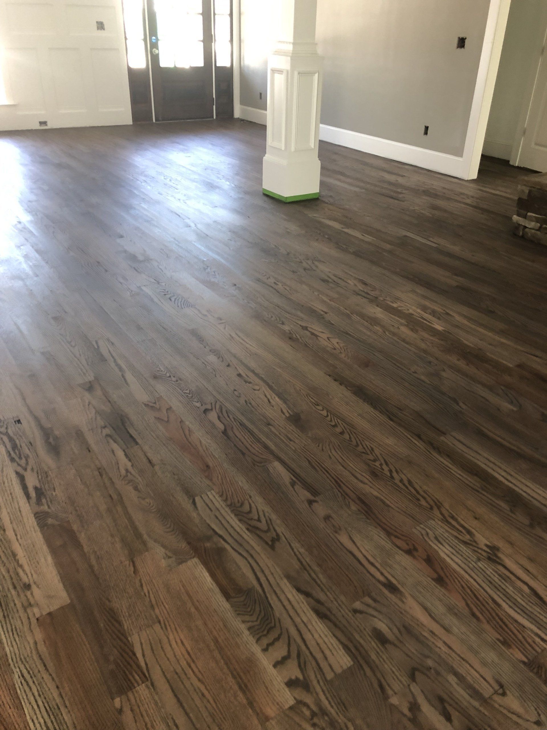 A living room with hardwood floors and a white column.