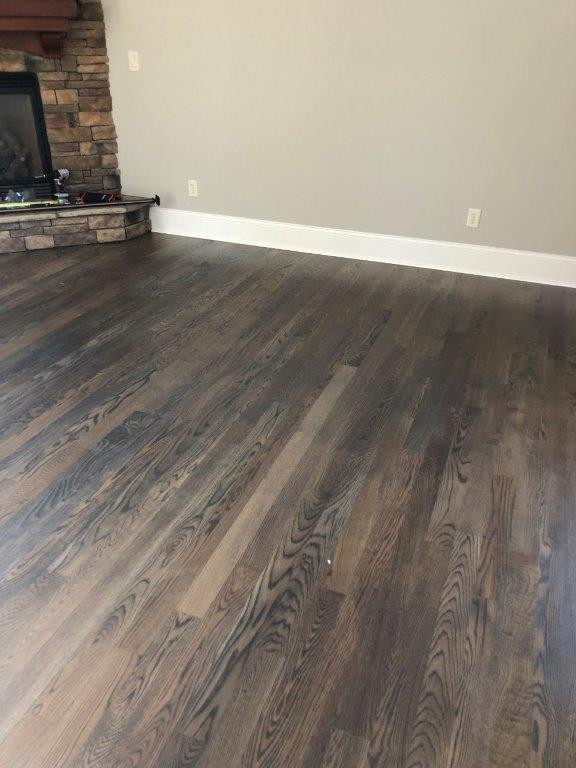 A living room with hardwood floors and a fireplace.