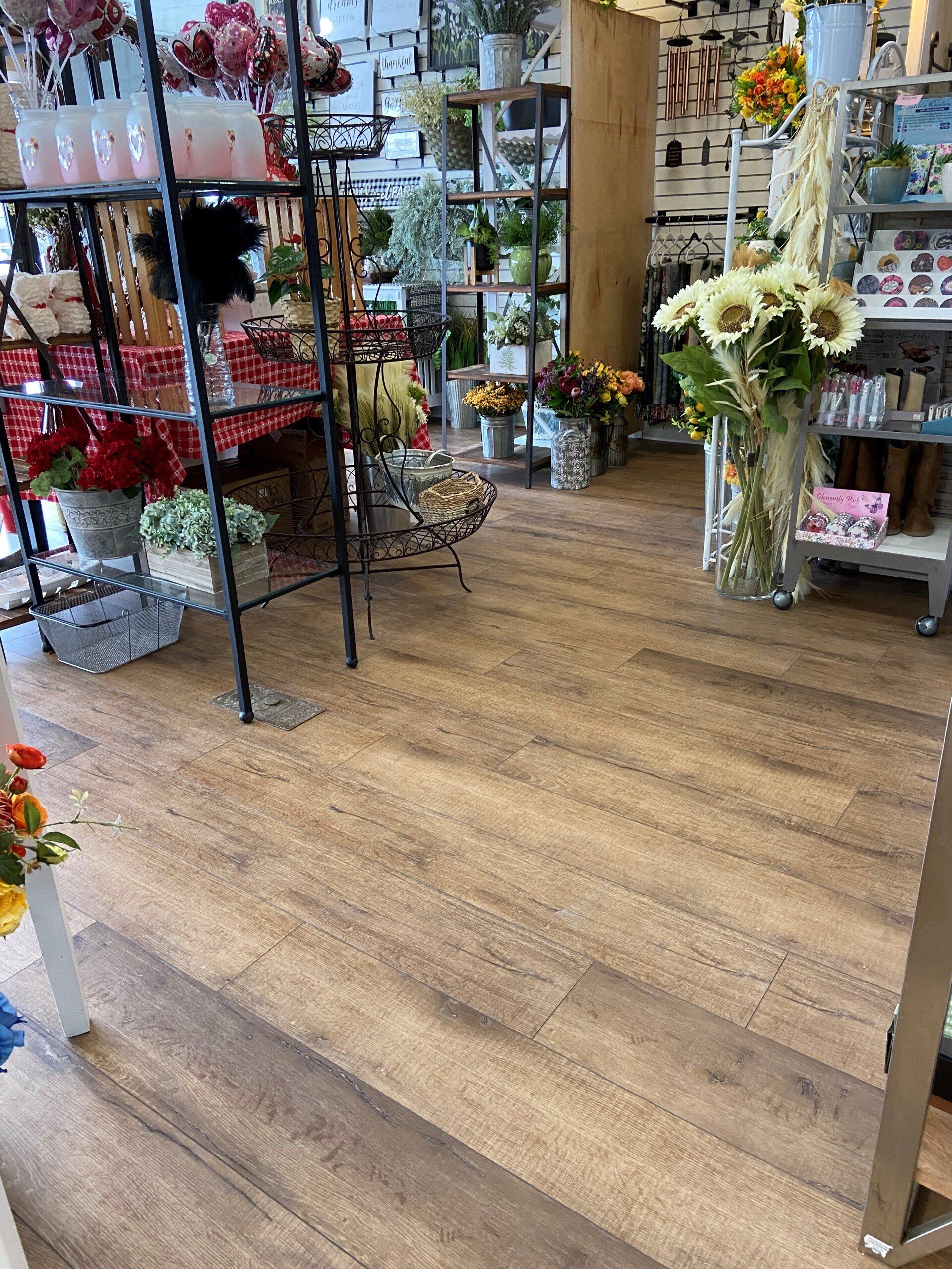 A flower shop filled with lots of flowers and candles.