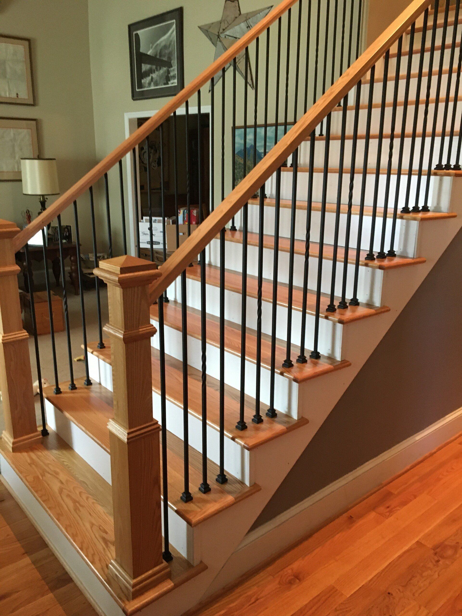 A wooden staircase with a metal railing in a living room
