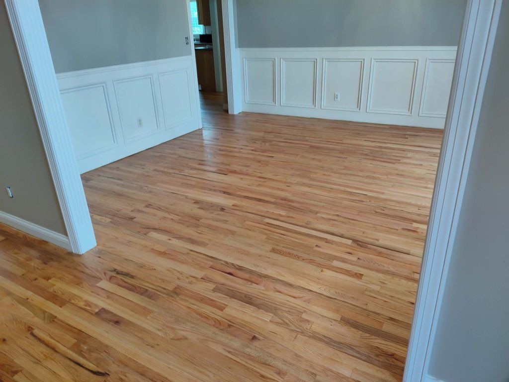 A living room with hardwood floors and white trim.