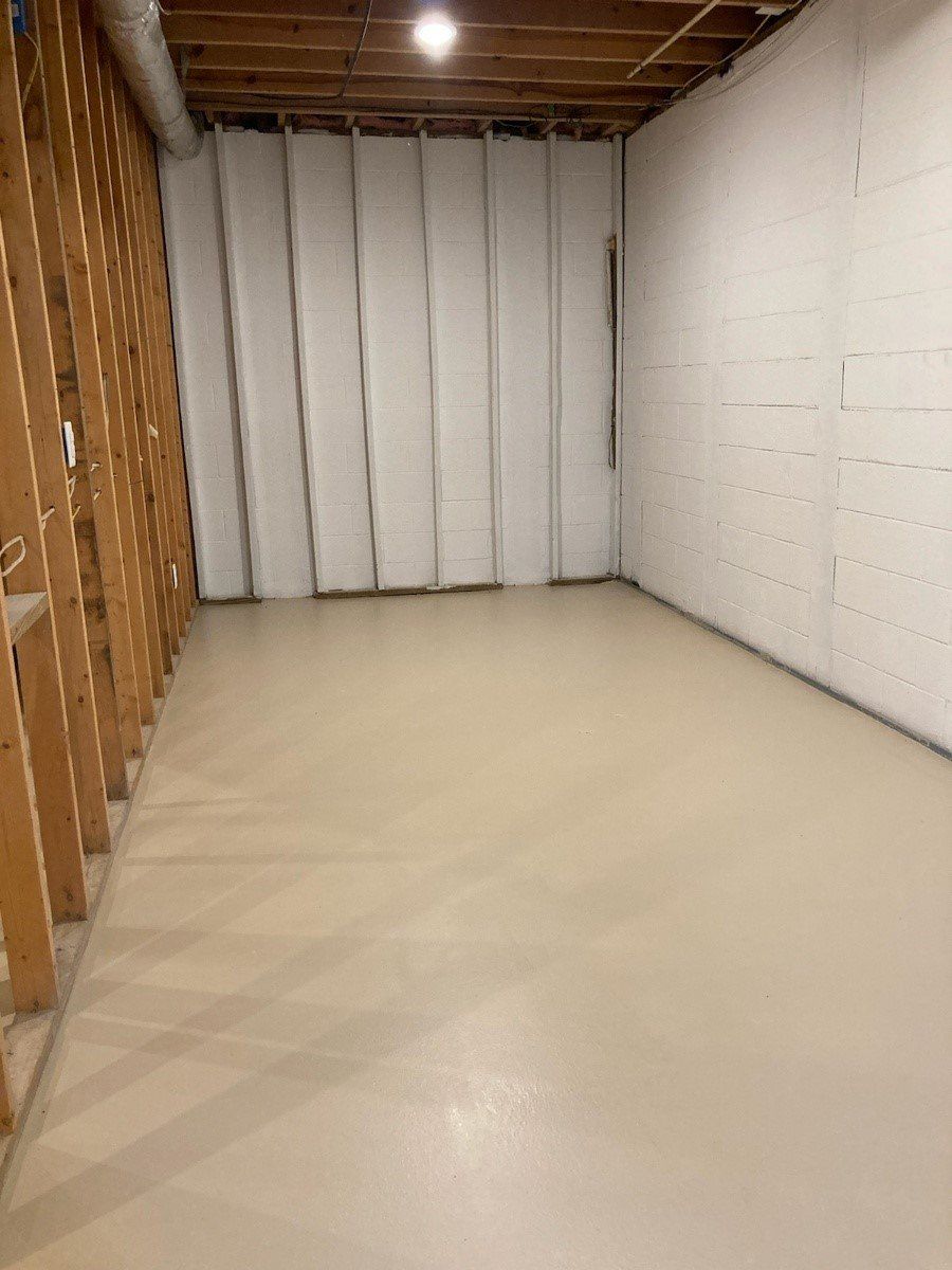 An empty basement with white walls and a white floor.