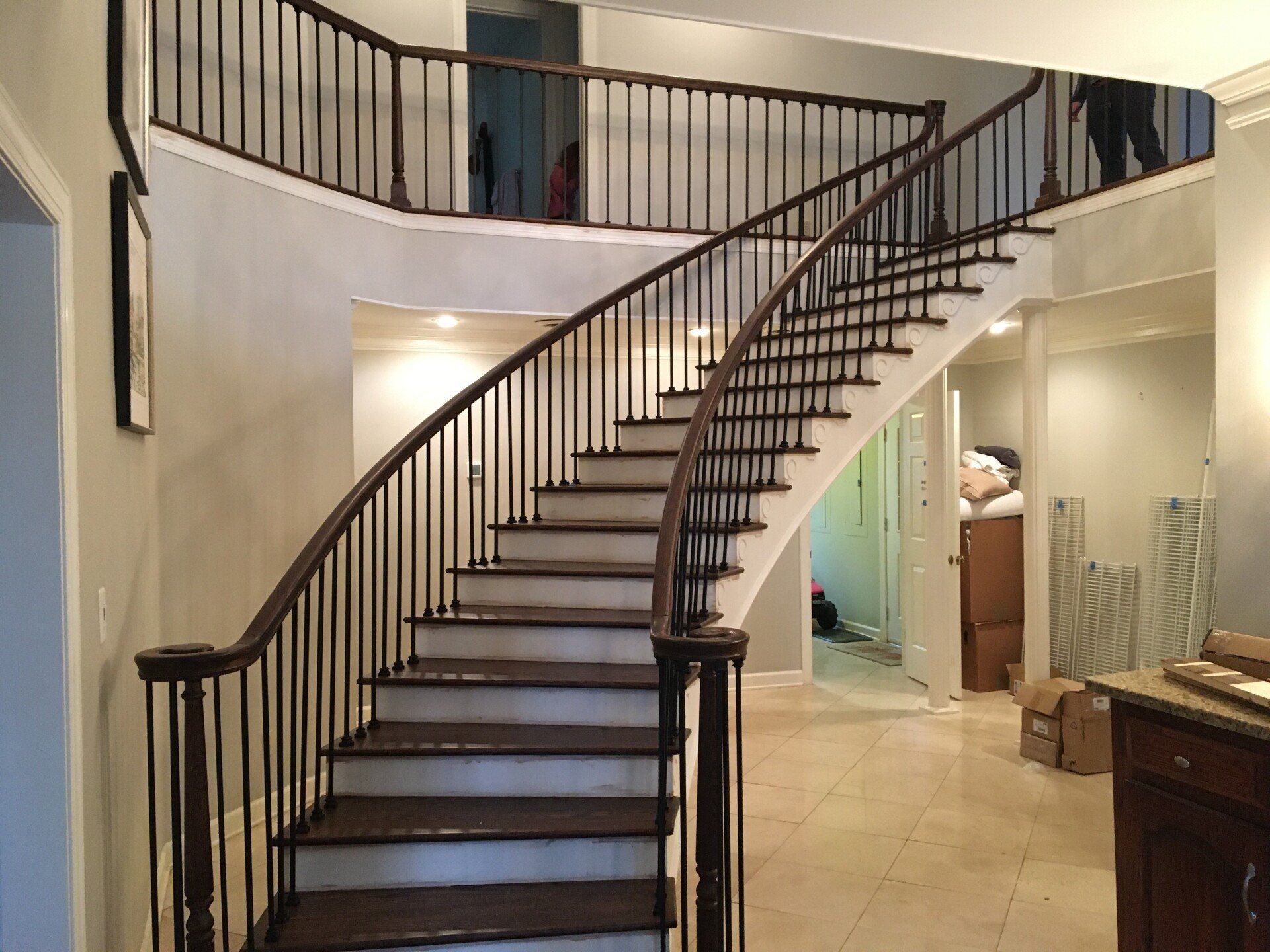 A curved staircase in a house with a metal railing