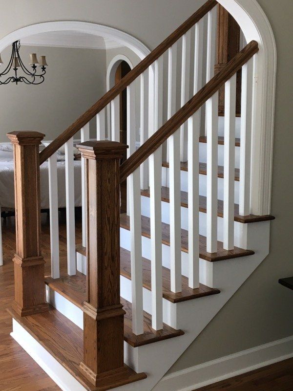 A staircase with a wooden railing and white steps