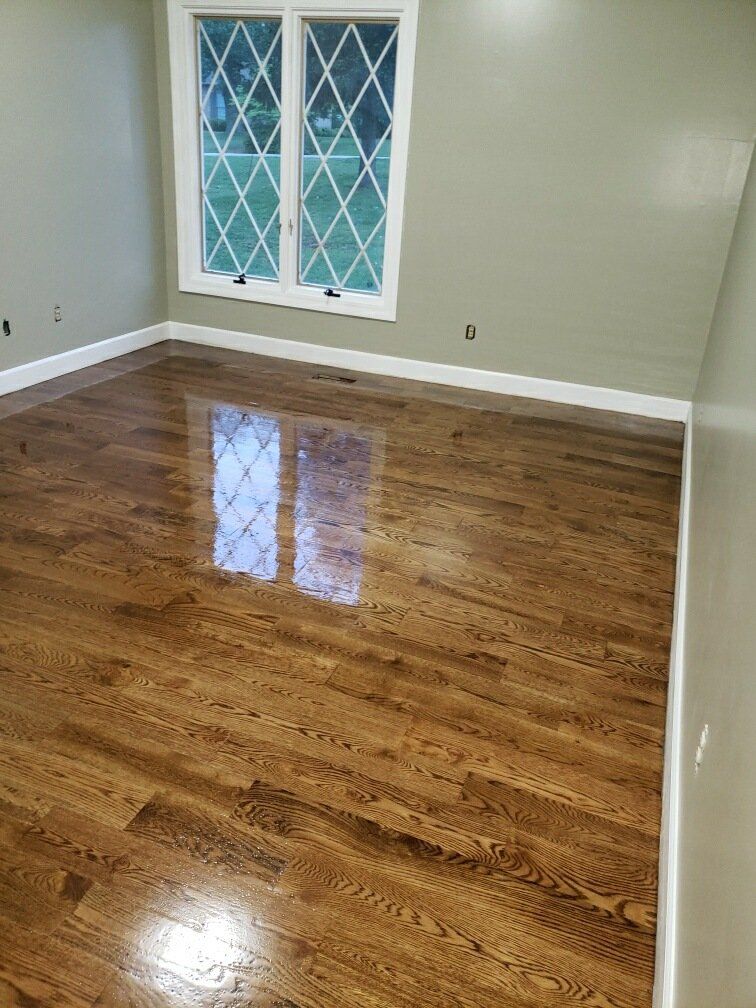 A room with hardwood floors and two windows.