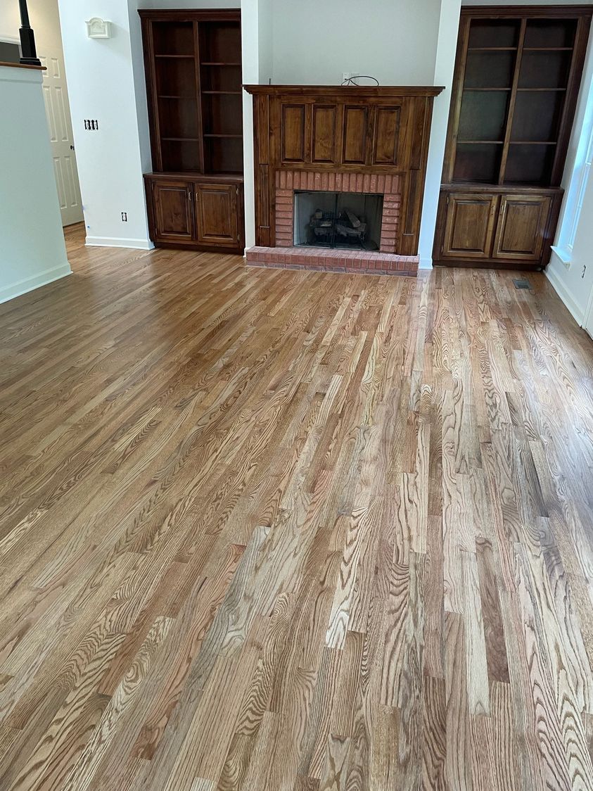 A living room with hardwood floors and a fireplace.