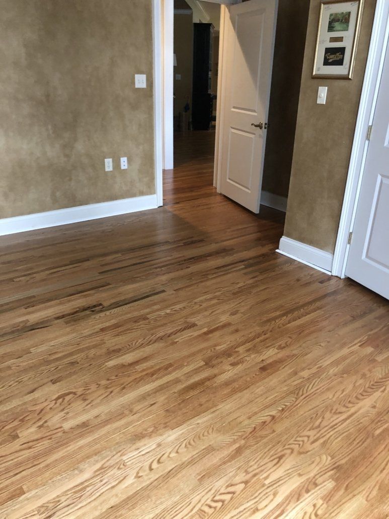 A living room with hardwood floors and a picture on the wall.