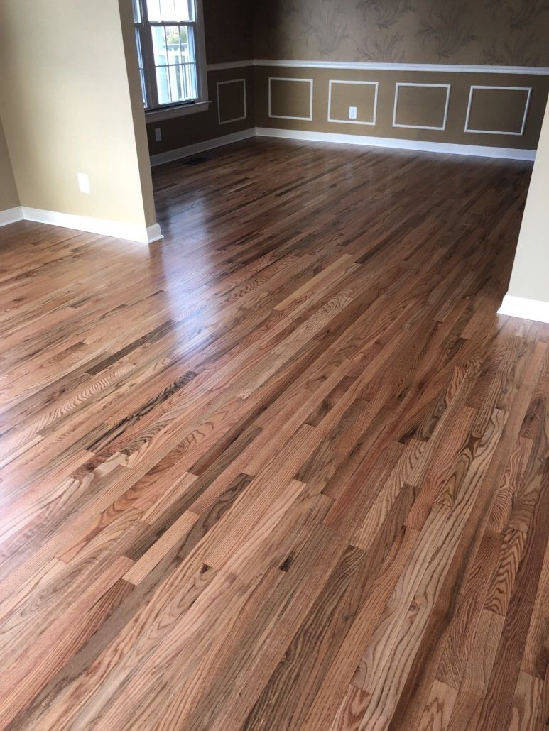 A living room with hardwood floors and a window.