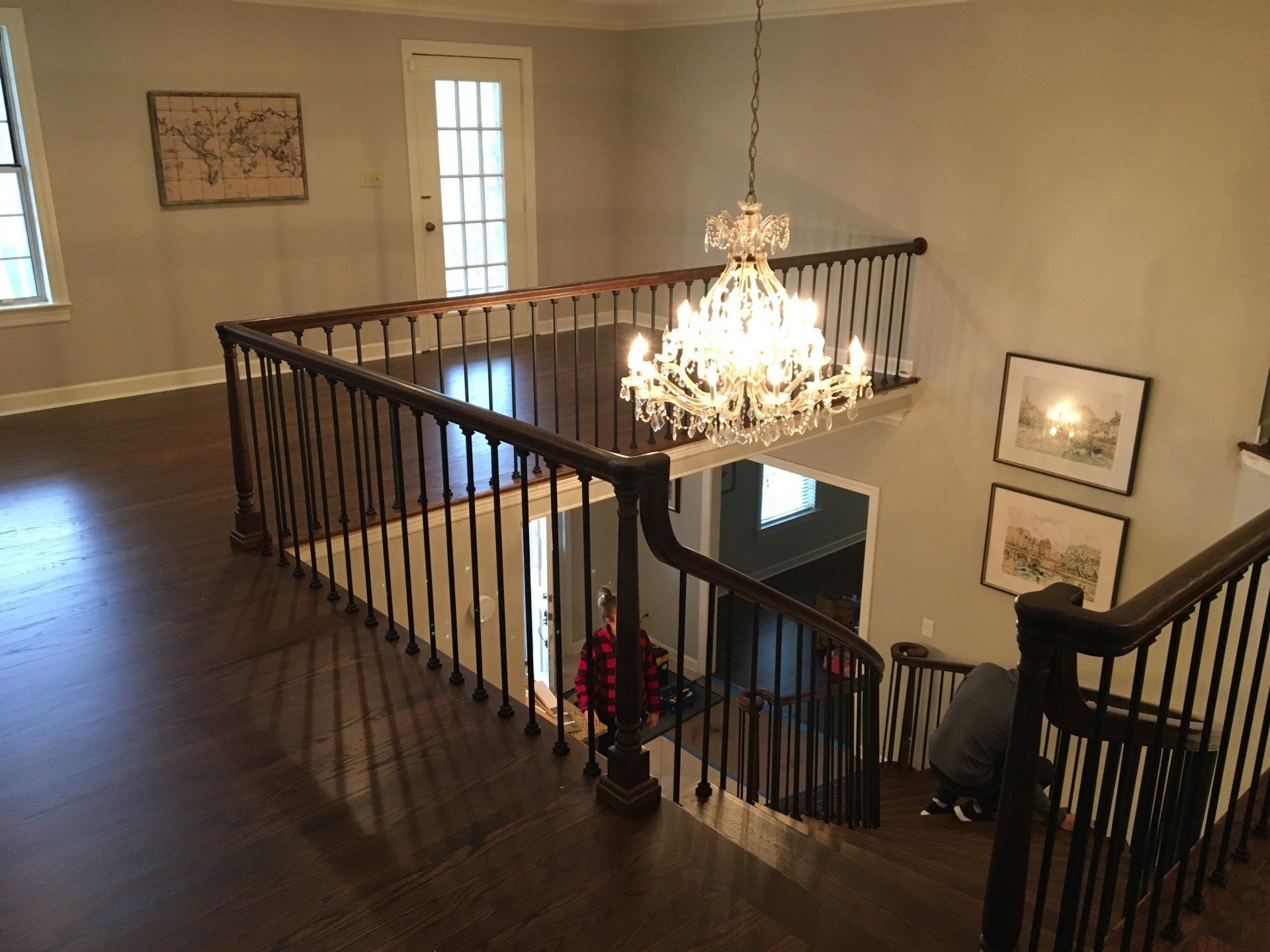 There is a chandelier hanging from the ceiling above the stairs.