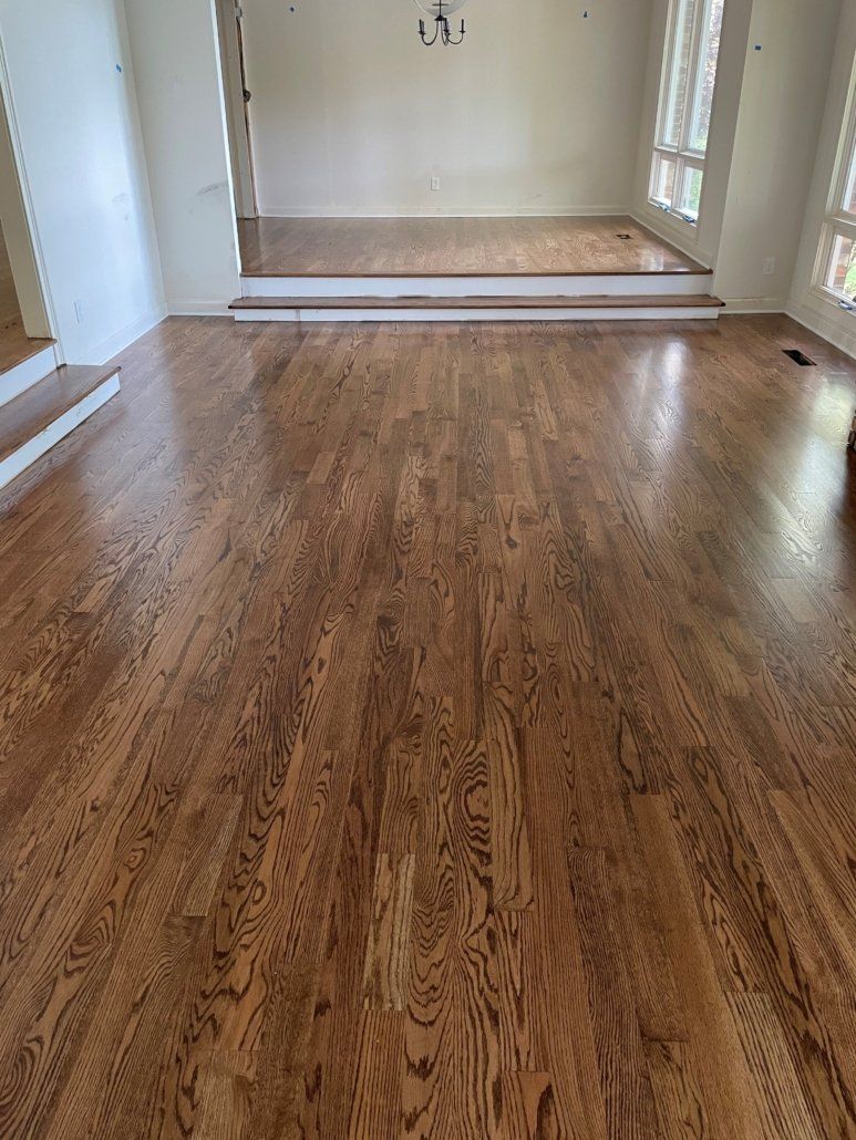 A living room with hardwood floors and white walls.