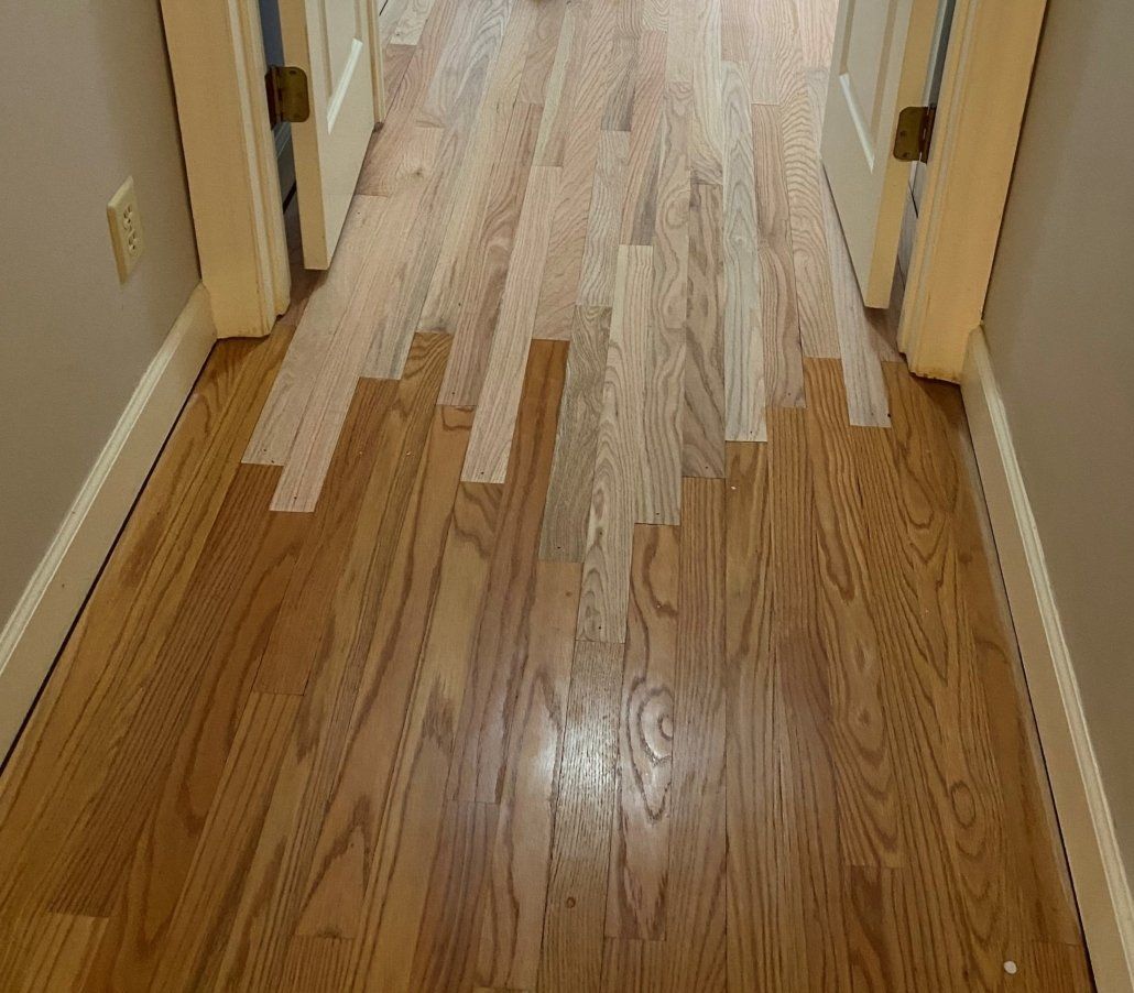 A hallway with hardwood floors and tape on the floor.