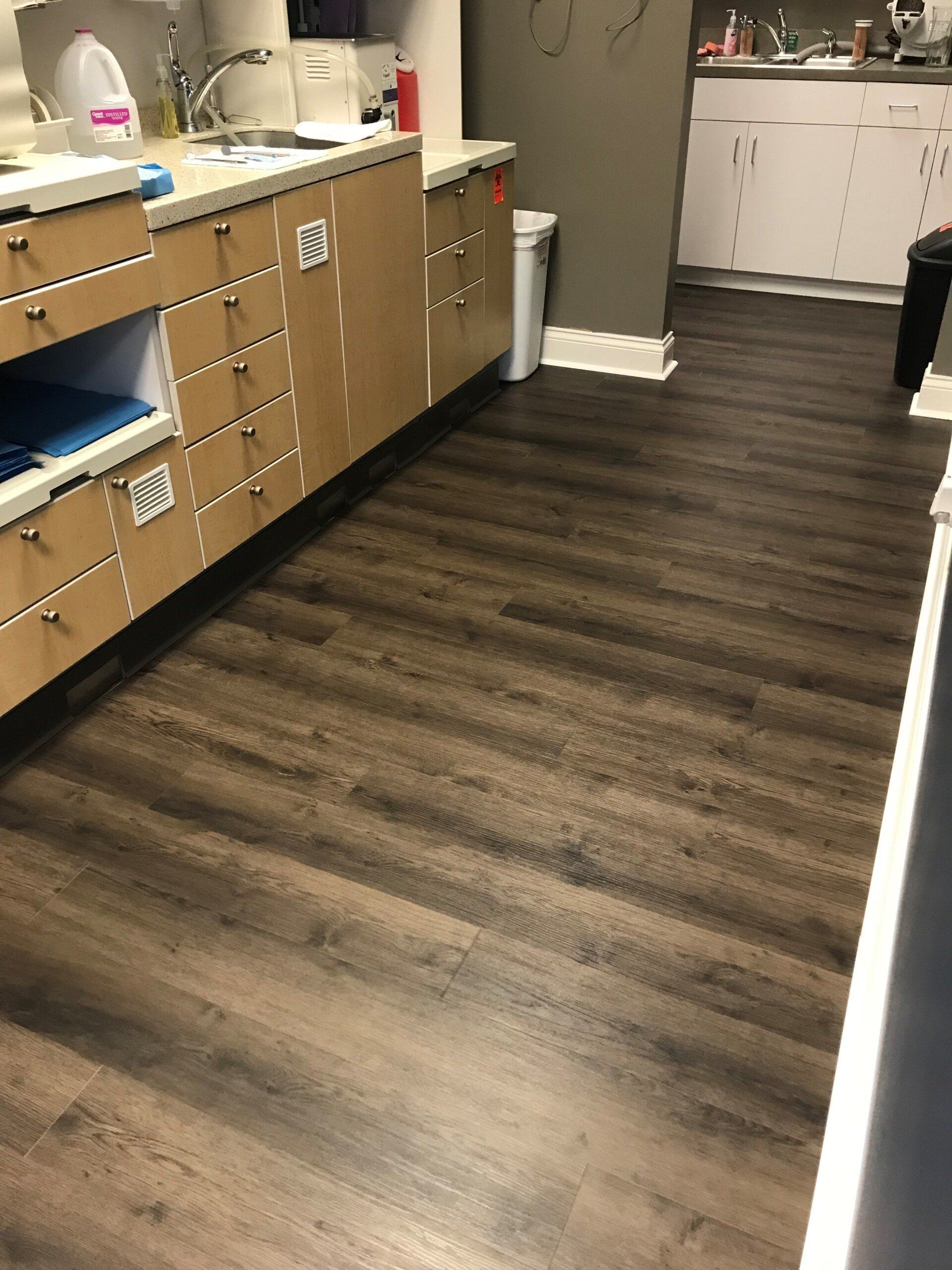 A kitchen with wooden cabinets and a wooden floor.