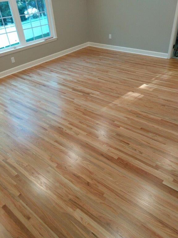 A living room with hardwood floors and a window.