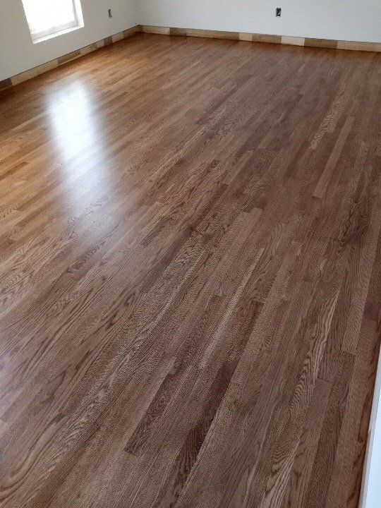 A large room with a wooden floor and white walls.