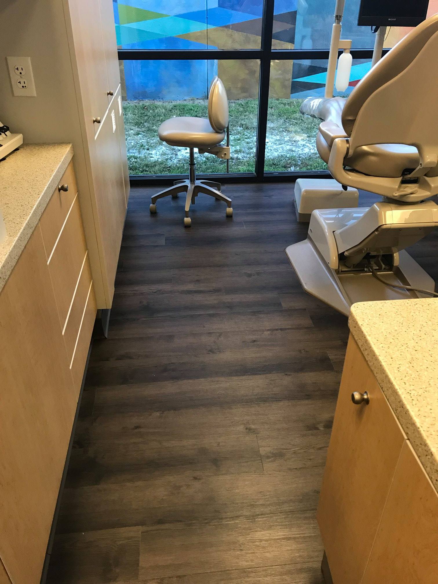 A dental office with a dental chair and a window.