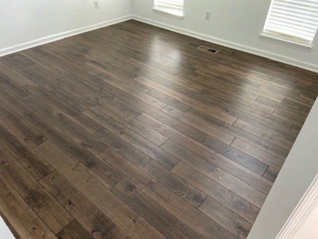 A room with a wooden floor and a window.