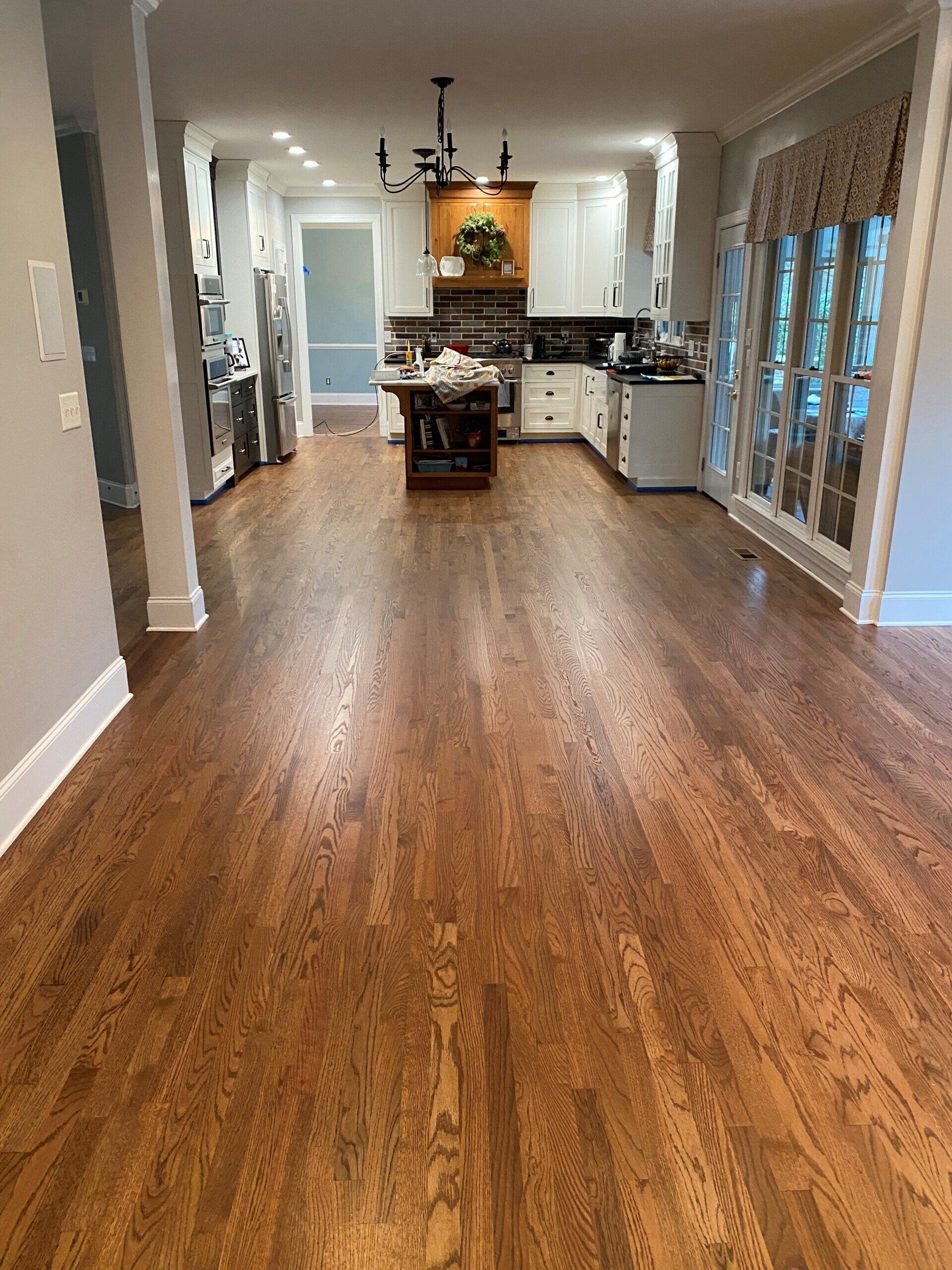 A kitchen with hardwood floors and a large island in the middle.