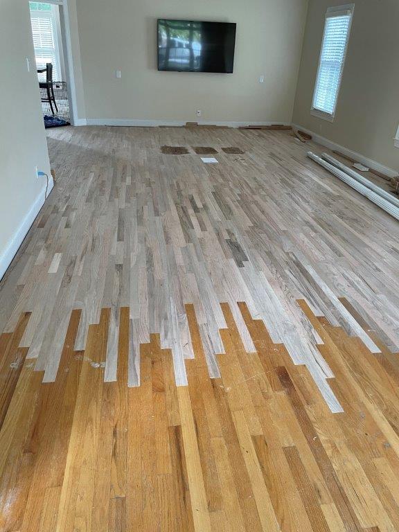 A living room with hardwood floors and a flat screen tv on the wall.