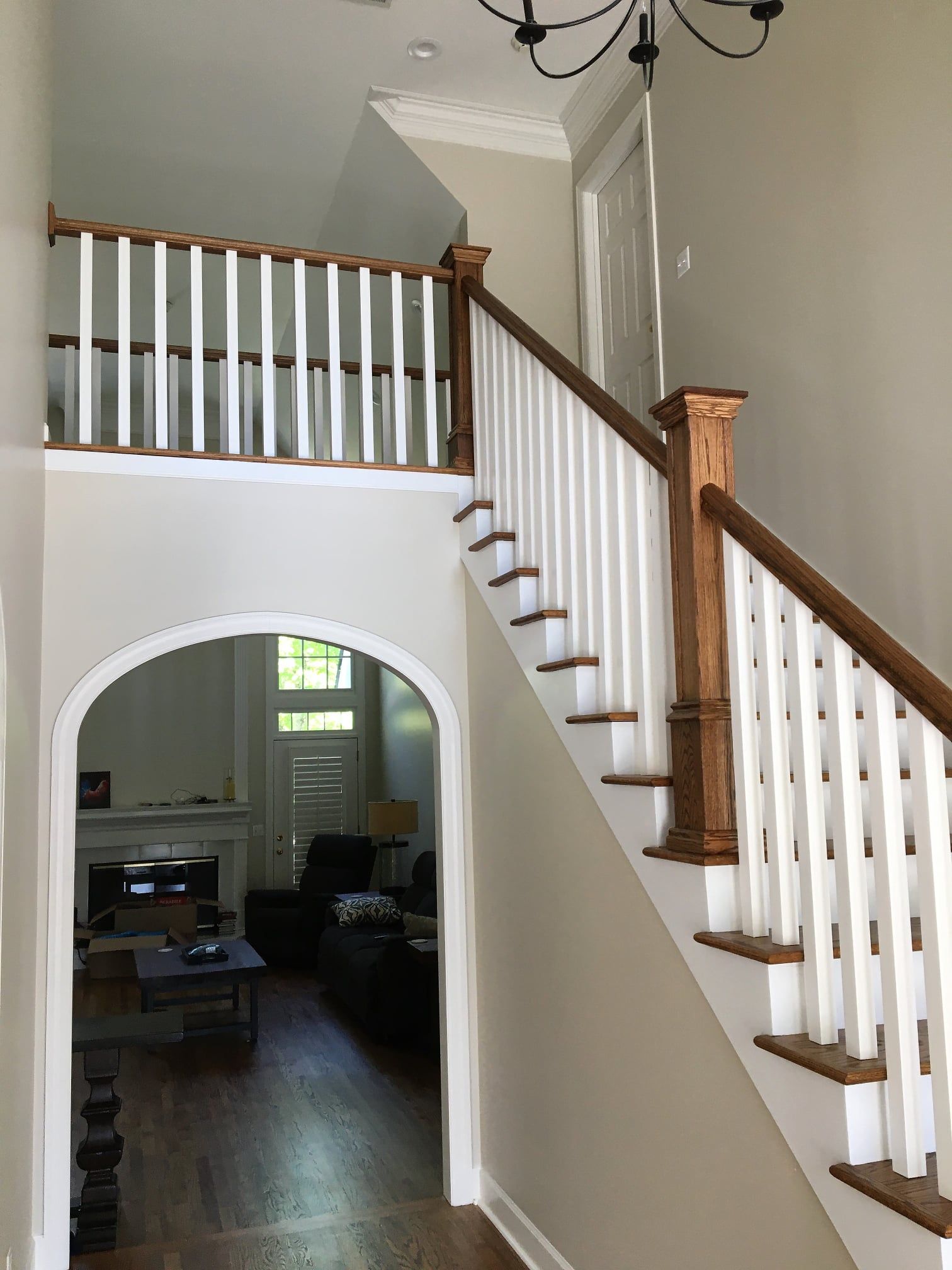 A staircase with white railings leading up to a living room