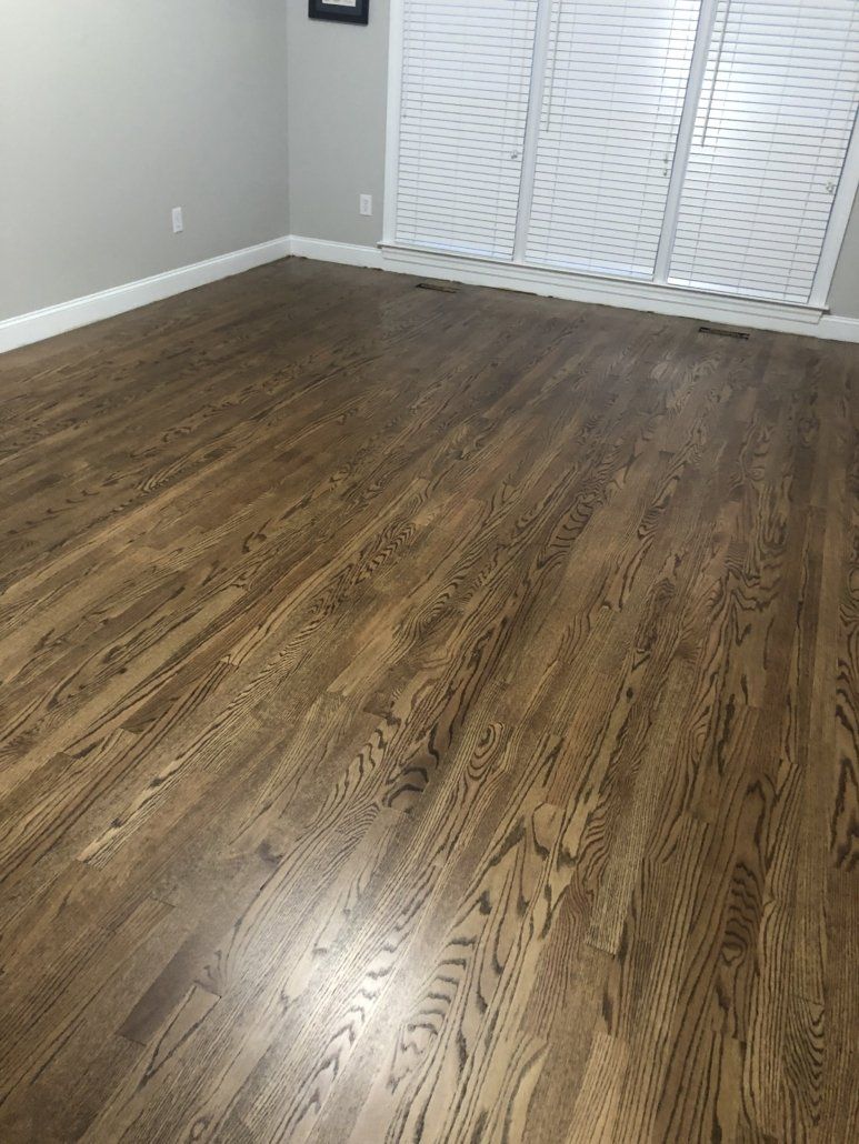 A living room with hardwood floors and white blinds.